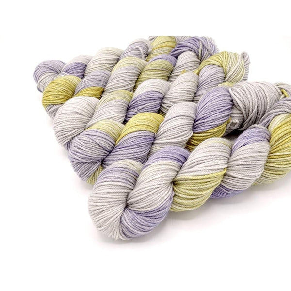 Skeins of Murky Depths Neptune DK Hypatica, a variegated  yarn in shades of pale pink, yellow and lavender.
