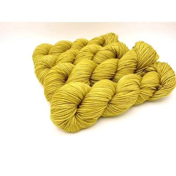 Skeins of Murky Depths Neptune DK Turmeric, a deep yellow with hints of green.